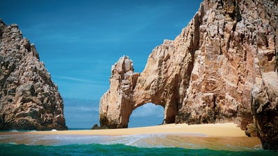 Brown rock formation on the sea during the day
